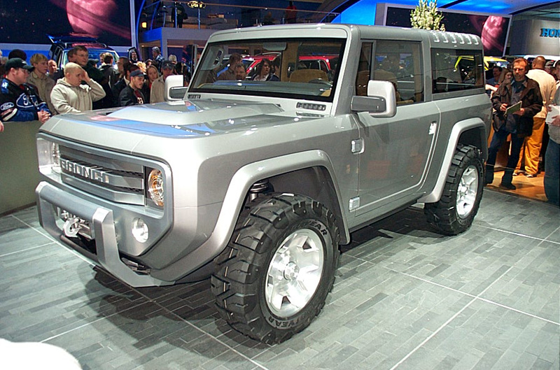 Silver boxy Bronco concept SUV on auto-show stand, crowd around it