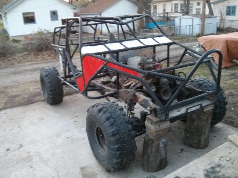 1986 Ford Bronco - This custom buggy frame is supported by wooden blocks, showing its off-road tires and exposed engine.