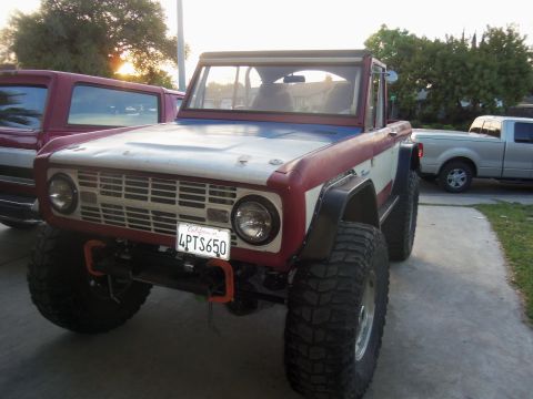 1968 Ford Bronco - 1968 Ford Bronco in front view, modified with large tires and custom paint scheme.