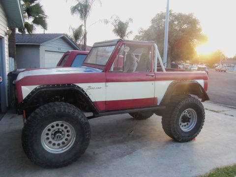1968 Ford Bronco - This modified Ford Bronco is parked in a driveway with a second vehicle visible behind it.