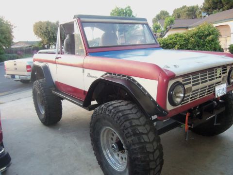 1968 Ford Bronco - A modified 1968 Ford Bronco is parked in a driveway next to a pickup truck.