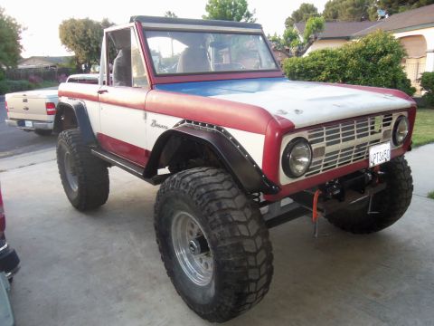 1968 Ford Bronco - This lifted 1968 Ford Bronco features a distinctive red, white, and blue paint scheme and aggressive off-road tires.