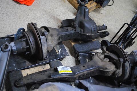 1986 Ford Bronco - Various Dana 50 TTB axle components are laid out on a workshop floor.