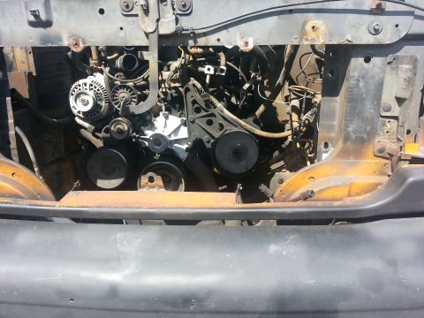 1994 Ford Bronco - The engine bay of a 1994 Ford Bronco is shown, with visible components and signs of rust.