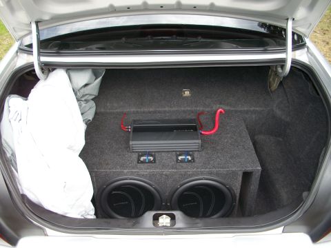 2003 Mercury Grand Marquis - The trunk of a car contains a custom subwoofer box with two speakers and an amplifier.