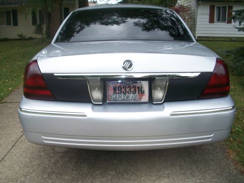 2003 Mercury Grand Marquis - Rear view of a silver sedan, identified as a 2003 Mercury Grand Marquis, its distinctive taillights and license plate.