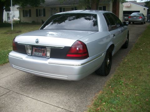 2003 Mercury Grand Marquis - The rear of a silver 2003 Mercury Grand Marquis is shown parked on a concrete driveway.