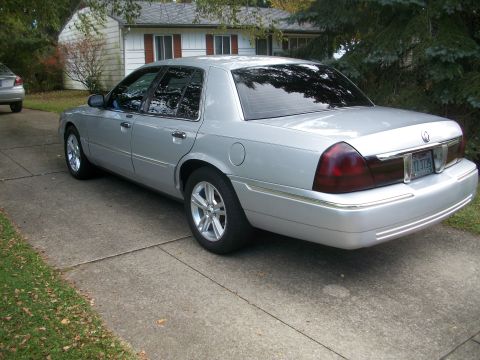 2003 Mercury Grand Marquis - Rear 3/4 view of a silver 2003 Mercury Grand Marquis parked in a driveway.