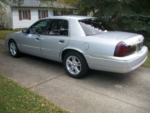 2003 Mercury Grand Marquis - Silver 2003 Mercury Grand Marquis seen from a 3/4 front angle on a suburban driveway.
