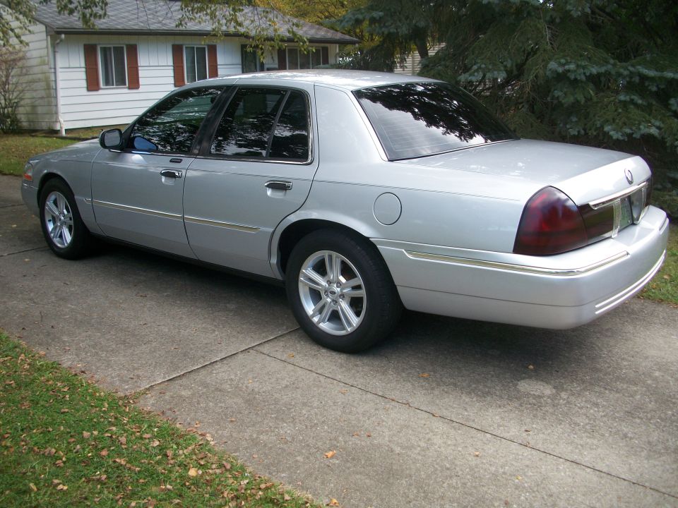 2003 Mercury Grand Marquis parked on a concrete driveway in front of a house