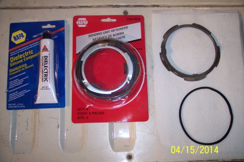 1990 Ford Bronco - Parts laid out on a surface, including a tube of silicone compound and a package of fuel sending unit retainers.