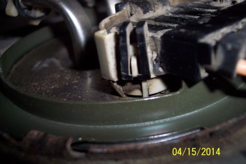 1990 Ford Bronco - Close-up of a fuel pump electrical connector, showing a green seal and wiring harness.