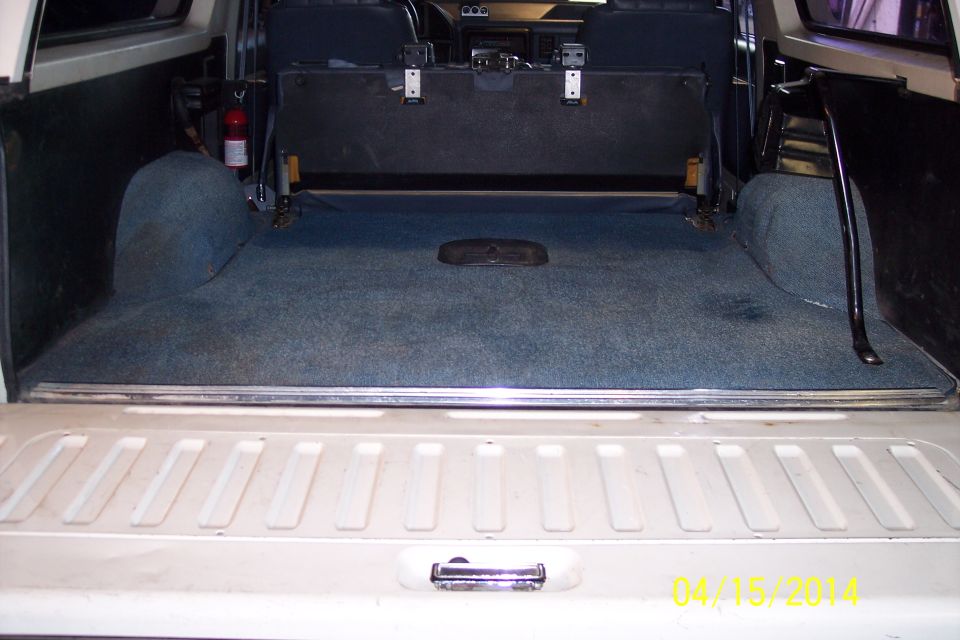 1990 Ford Bronco interior cargo area with blue carpet and folded rear seat