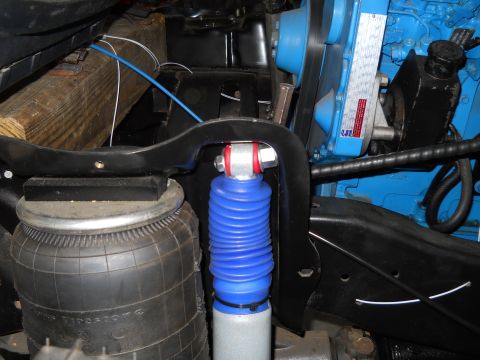 1992 Ford Bronco - Close-up view of the engine bay, a blue engine block, air suspension, and a blue shock absorber.