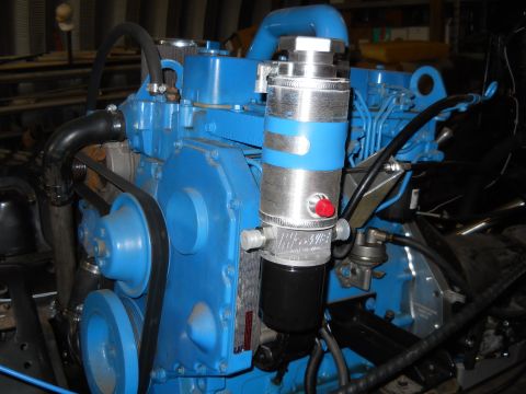 1992 Ford Bronco - Close-up of a blue engine with an aftermarket oil filter and associated plumbing.
