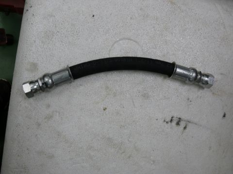 Brake hose with metal fittings and readable text on the rubber section