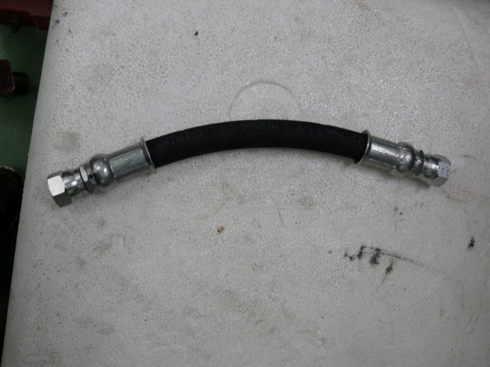 Brake hose with metal fittings and readable text on the rubber section
