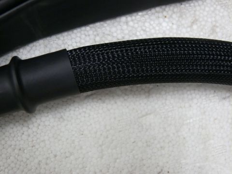 Black automotive wiring harness with braided sleeve and rubber boot