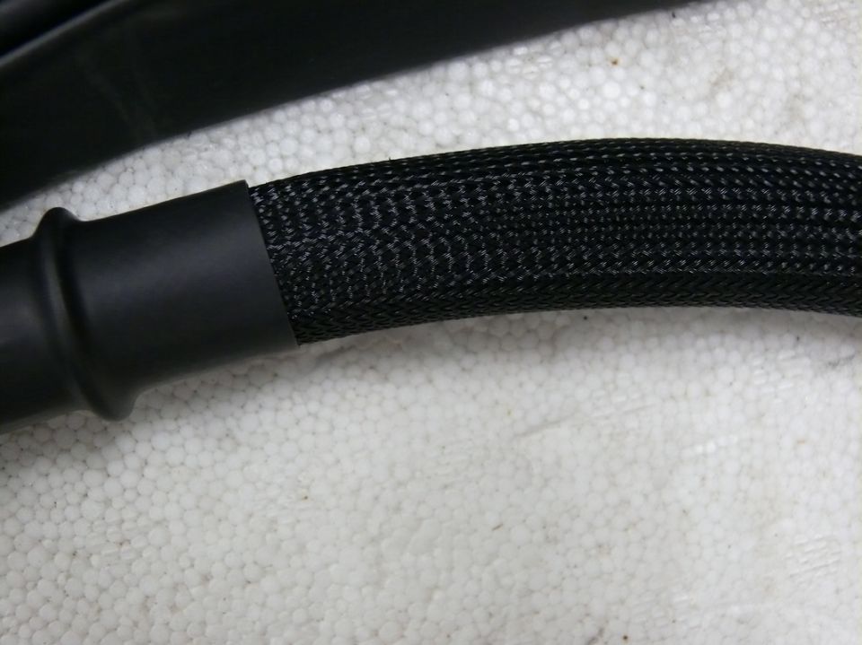 Black automotive wiring harness with braided sleeve and rubber boot