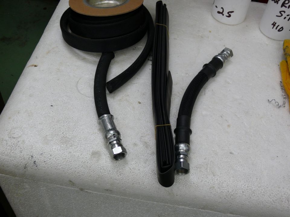 Black brake hoses and rubber trim on a white surface
