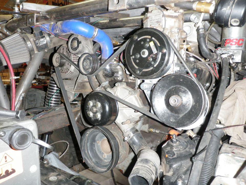 Engine bay with serpentine belt system, AC compressor, and power steering pump