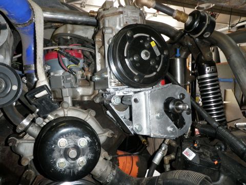 1961 International Scout 800 - Close-up view of engine components including an AC compressor and water pump.