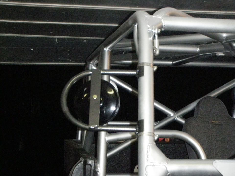 Roll cage structure with a round black mirror attached to a metal bar