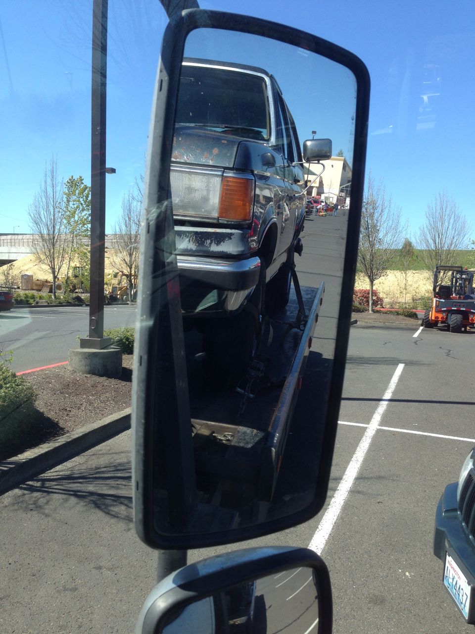 Dark blue Ford Bronco on a tow truck, front end visible