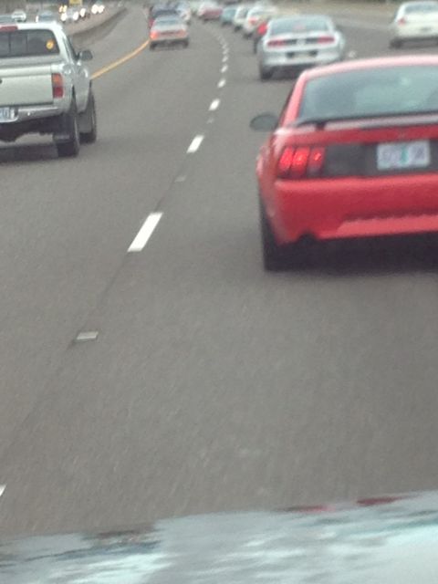 1989 Ford Bronco - Traffic on the highway includes a red sports car and a silver pickup truck.