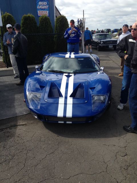 1989 Ford Bronco - A blue Ford GT with white racing stripes is parked at an outdoor event.