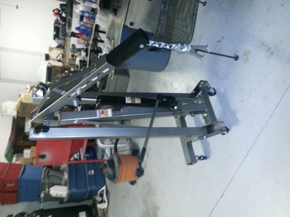 Engine hoist in a cluttered garage with shelves and boxes