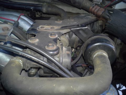 1991 Ford F-250 - Close-up view of engine components, including hoses and metal brackets. Text from a watermark is visible at the bottom.