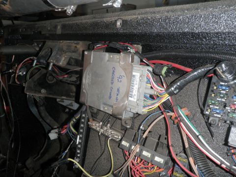 1961 International Scout 800 - Close-up of a vehicle's complex electrical system, showing an ECU and numerous wires and relays.