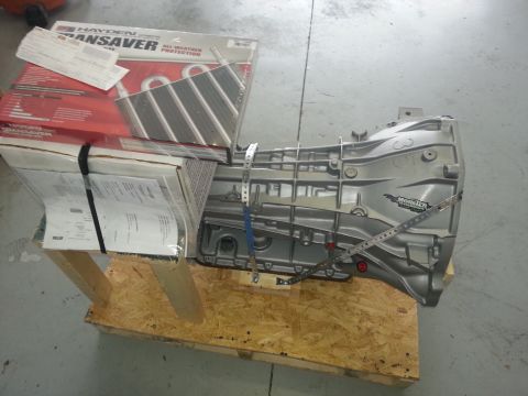 1994 Ford Bronco - A transmission and its associated parts are secured on a wooden pallet.