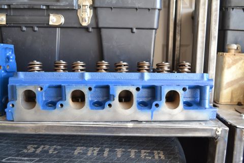 1981 Ford F-250 - A blue engine cylinder head with valve springs is displayed, with a toolbox in the background.