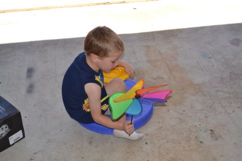 1981 Ford F-250 - A young boy sits on a blue ring, engrossed in playing with a vibrant pinwheel.