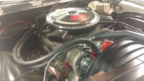 1976 Pontiac Trans Am - Close-up view of a car's engine compartment, showing the air cleaner and alternator.