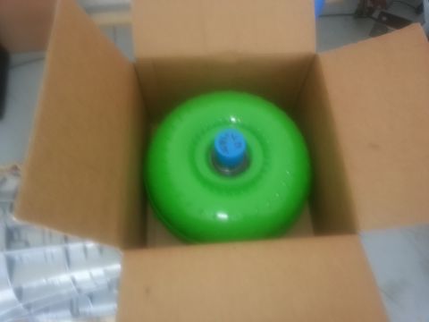 1994 Ford Bronco - A green torque converter sits inside a cardboard box, ready for installation or shipping.