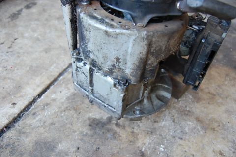 2006 Honda RANCHER - This is a close-up view of a dirty engine part with a black connector.