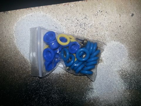 1994 Ford Bronco - A bag of assorted blue and yellow O-rings is shown on a speckled surface.