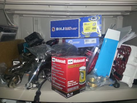 1994 Ford Bronco - Various automotive parts are organized on shelves, including engine components and filters.