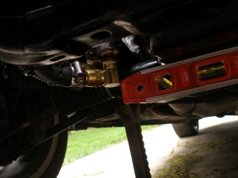 2010 Hyundai Genesis - A level is used to check the orientation of the oil cooler lines on a vehicle.