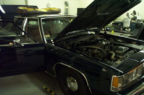 1991 Ford LTD Crown Victoria - Engine compartment of a 1991 Ford Crown Victoria LTD, with the hood open and a light bar visible on the roof.