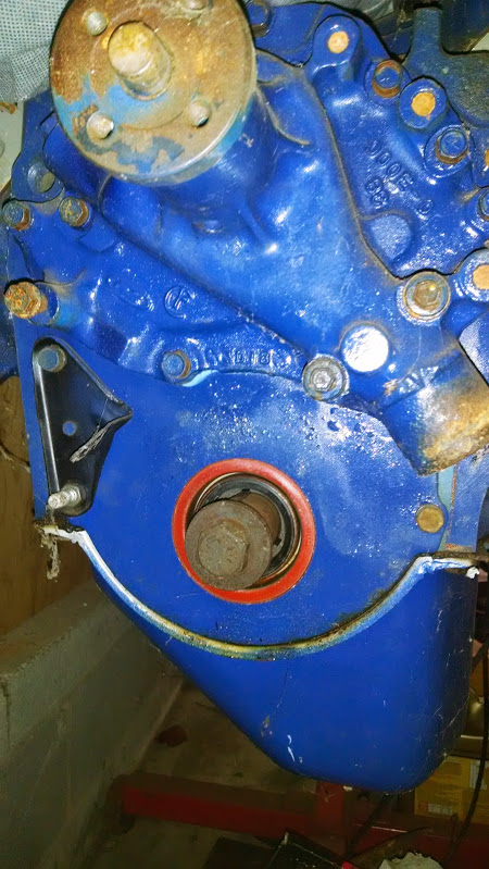 1979 Ford F-150 - A blue engine part is shown with visible casting marks and a red seal around a central bolt.