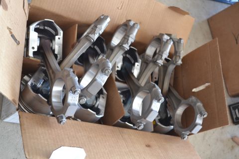 1981 Ford F-250 - Several pistons with connecting rods are packed in a cardboard box.