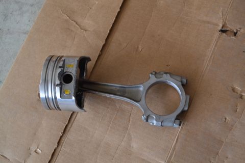 1981 Ford F-250 - A piston and connecting rod assembly is shown resting on a piece of cardboard.