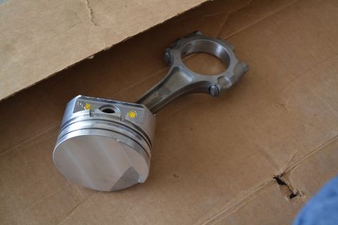 1981 Ford F-250 - A piston and connecting rod assembly rests inside a cardboard box, suggesting engine repair or reassembly.