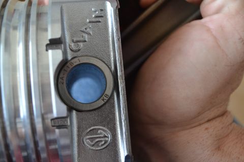 1981 Ford F-250 - Close-up of a metal part a blue filter and stamped text, held by a person's hand.