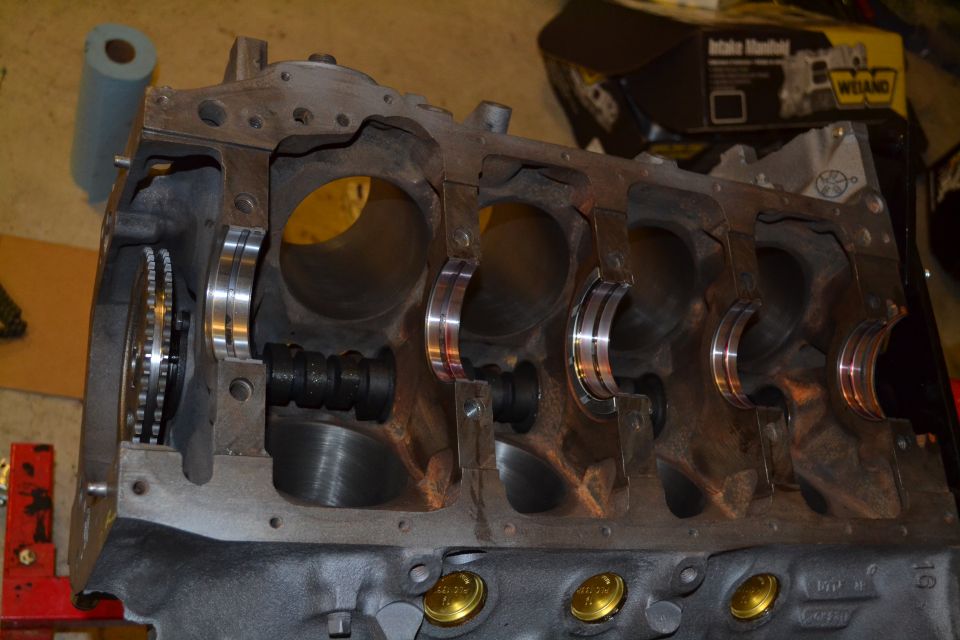 Engine block with crankshaft bearings installed, showing cylinder bores and timing chain gear