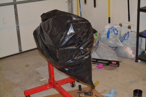 1981 Ford F-250 - Engine covered in a black tarp on a red engine stand, with storage bags in the background.